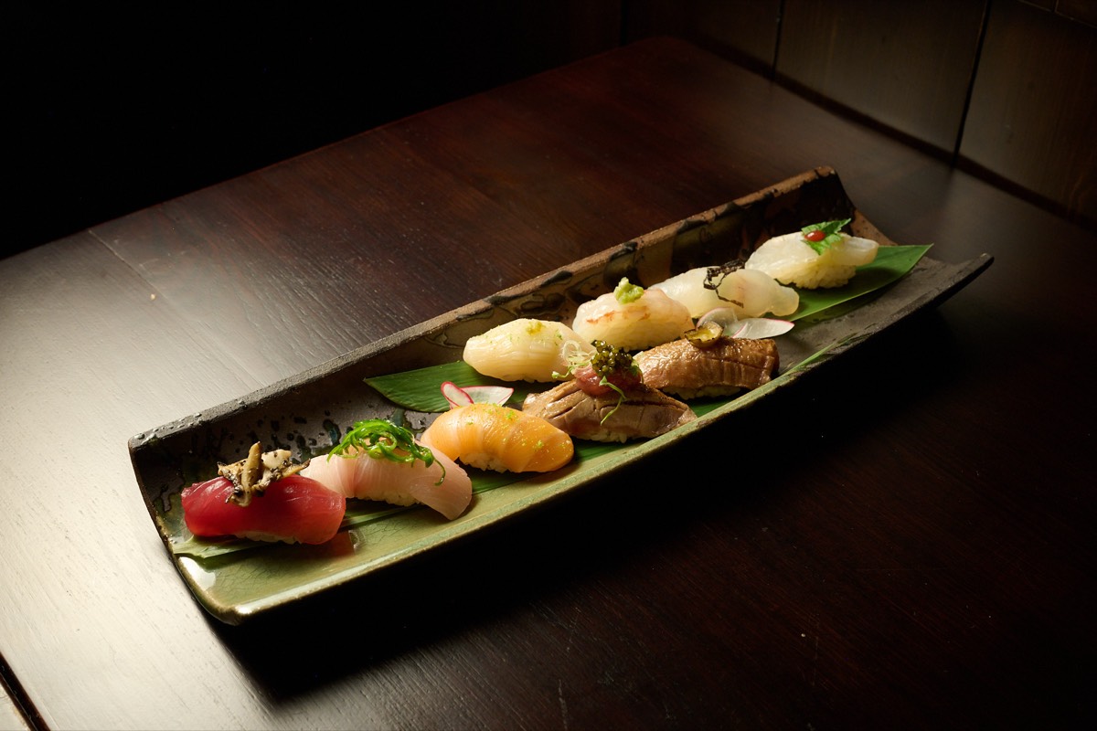 Close-up of hand-pressed nigiri sushi featuring fresh salmon and tuna at Showa Era Izakaya NYC