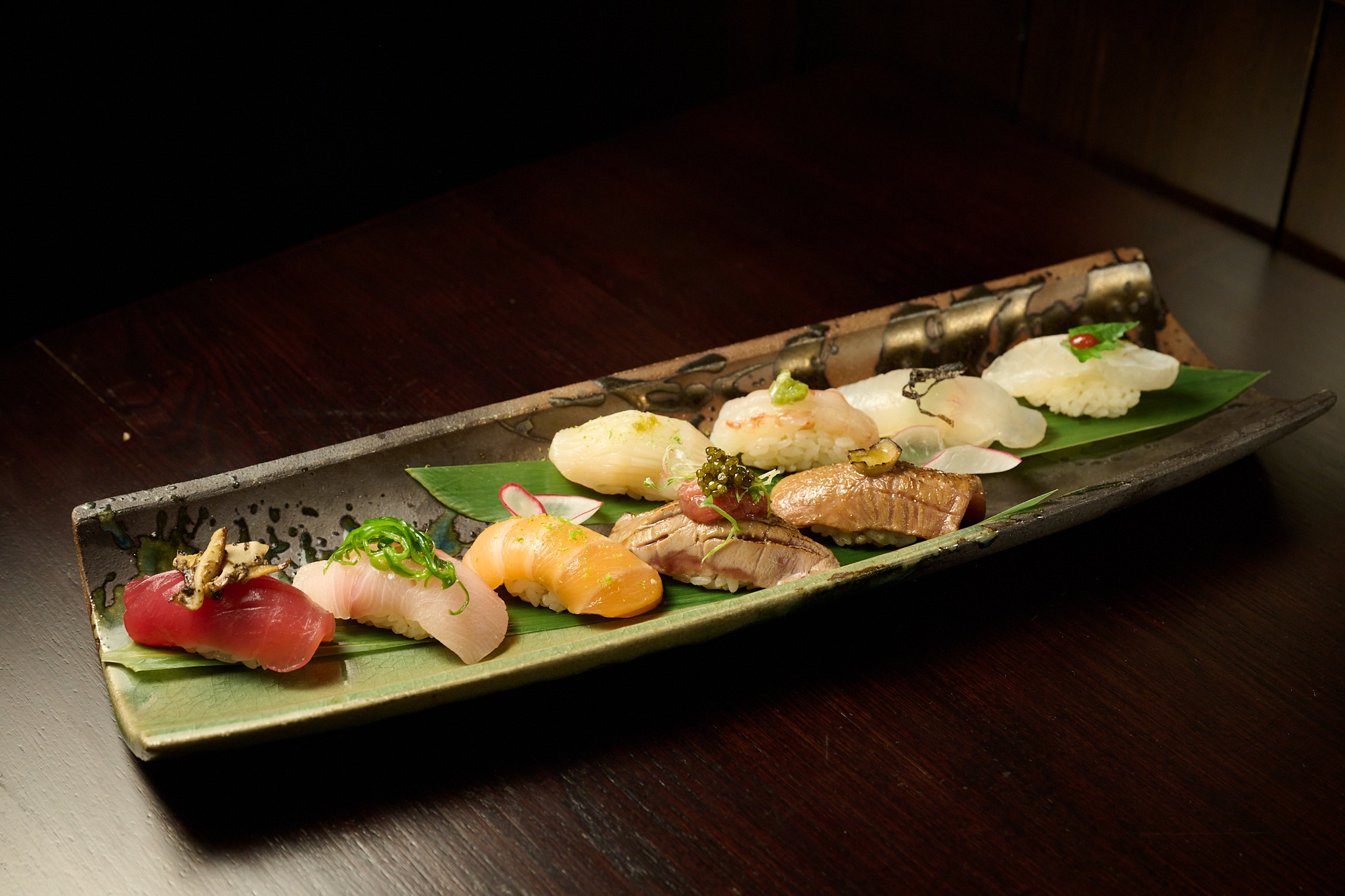 Premium nigiri sushi platter with tuna, salmon, yellowtail, and shrimp on banana leaf at Showa Era Izakaya