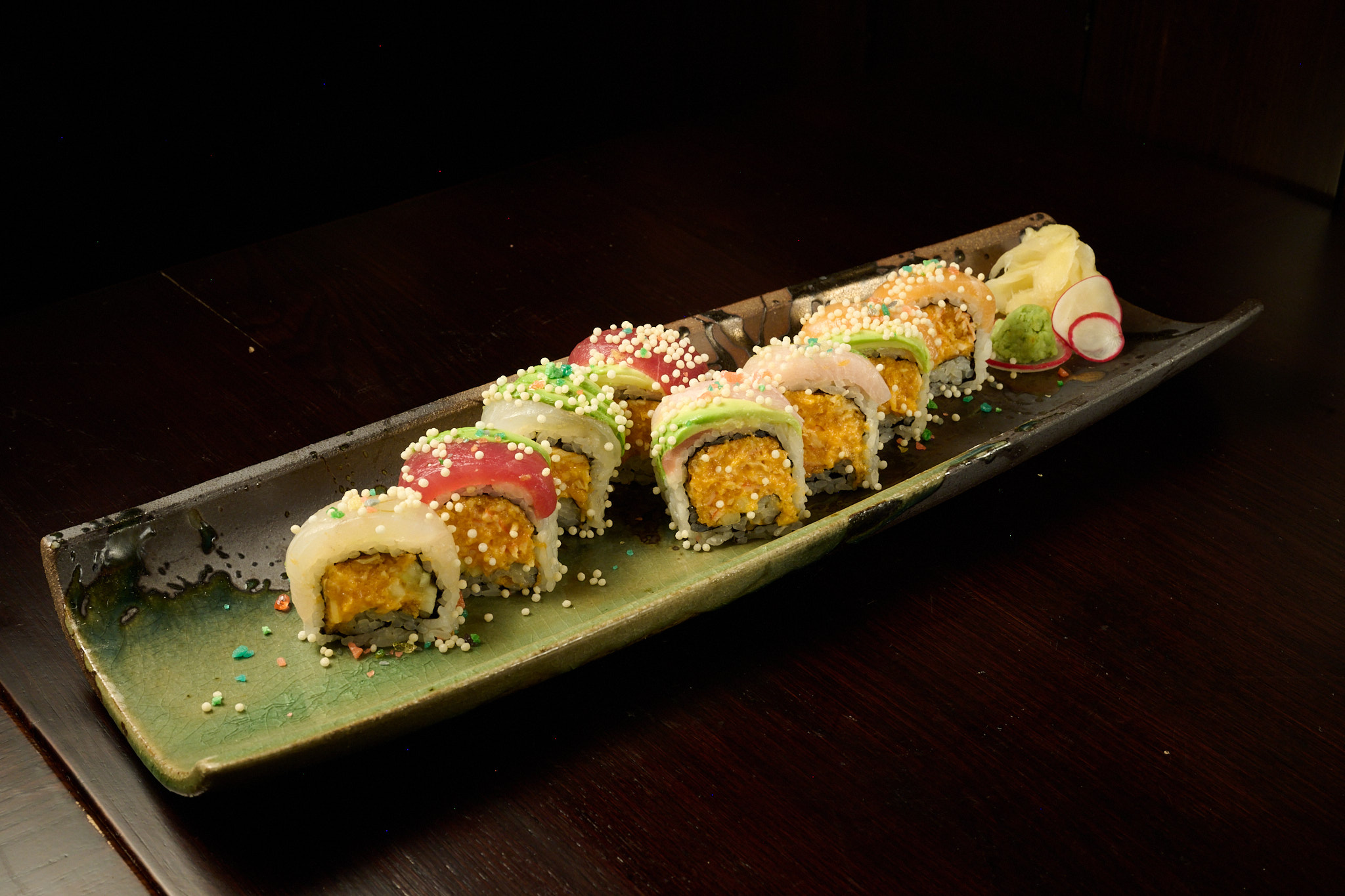 Colorful rainbow signature roll with tuna, salmon, and avocado topped with tempura crunch at Showa Era