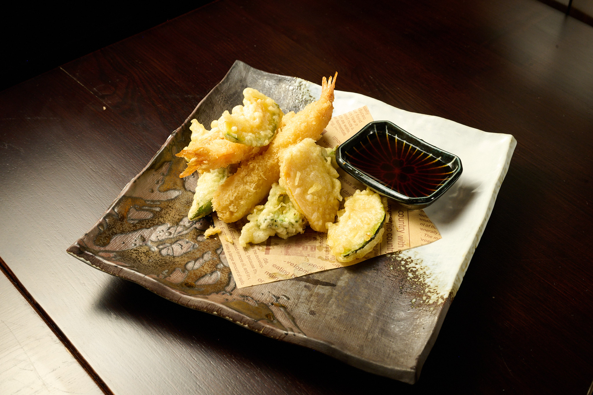 Crispy golden shrimp tempura with vegetable tempura and tentsuyu dipping sauce on artisan ceramic plate