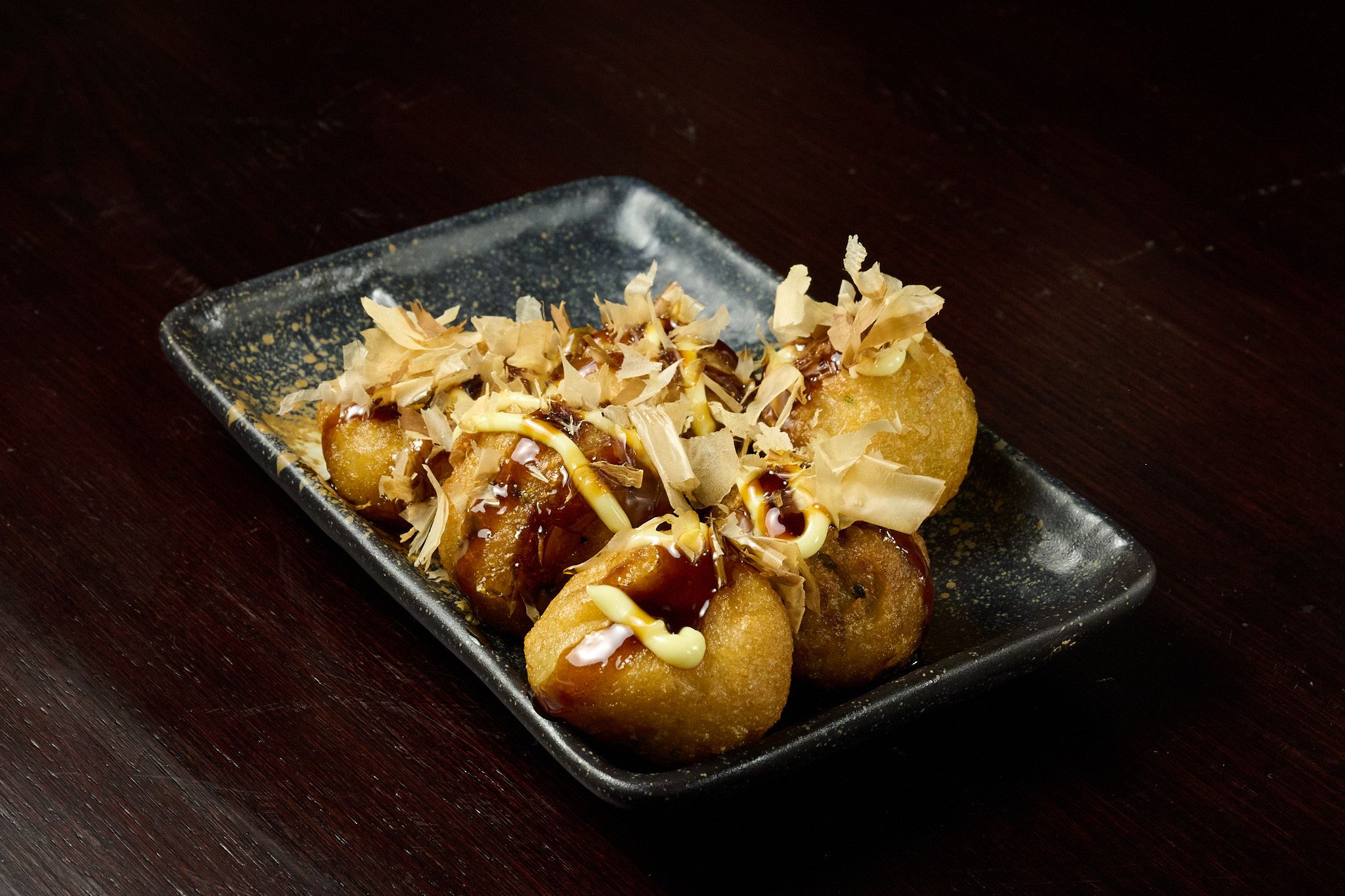 Golden takoyaki octopus balls with bonito flakes and sweet sauce at Showa Era Izakaya NYC