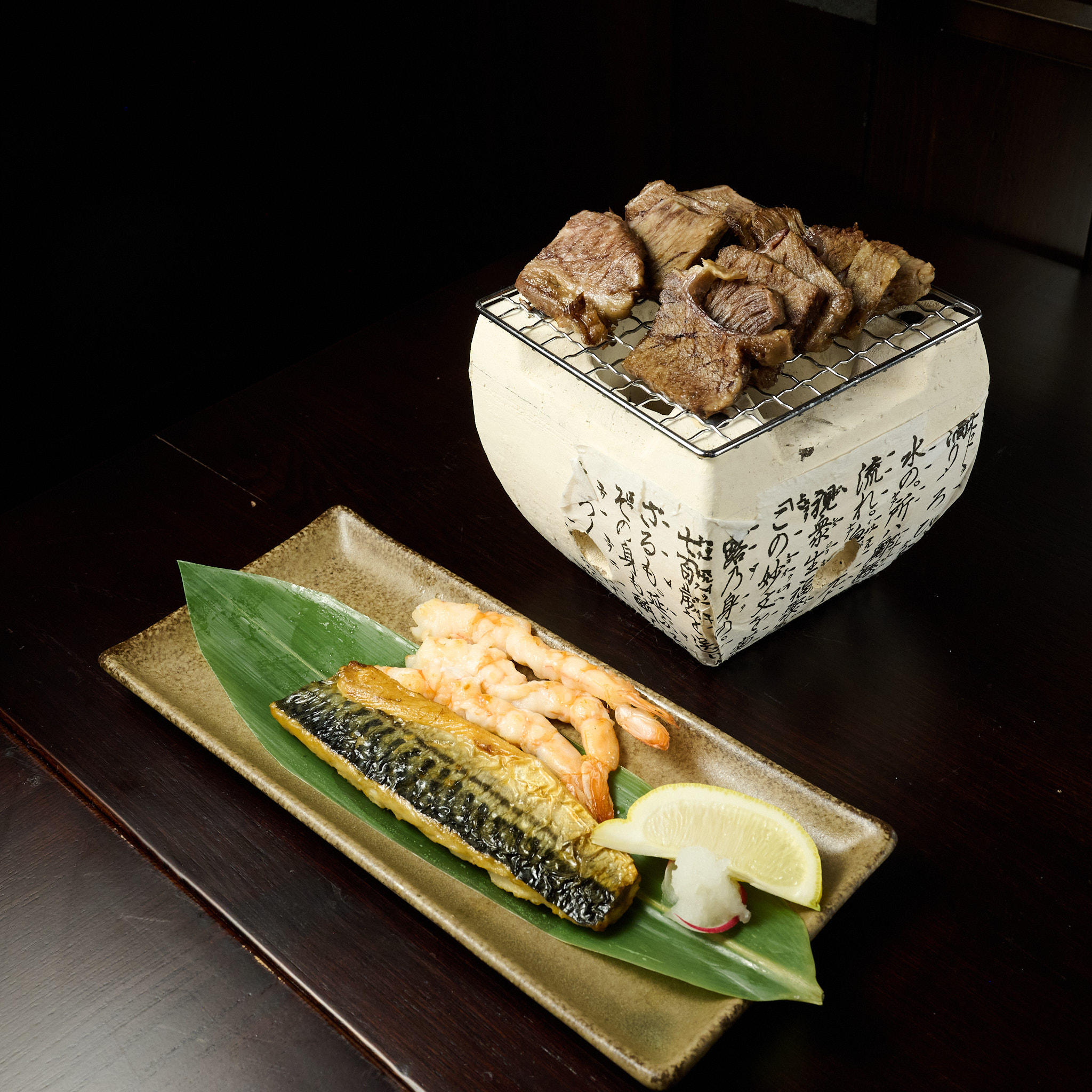 Wagyu beef grilling on traditional hibachi with grilled mackerel and shrimp at Showa Era Izakaya