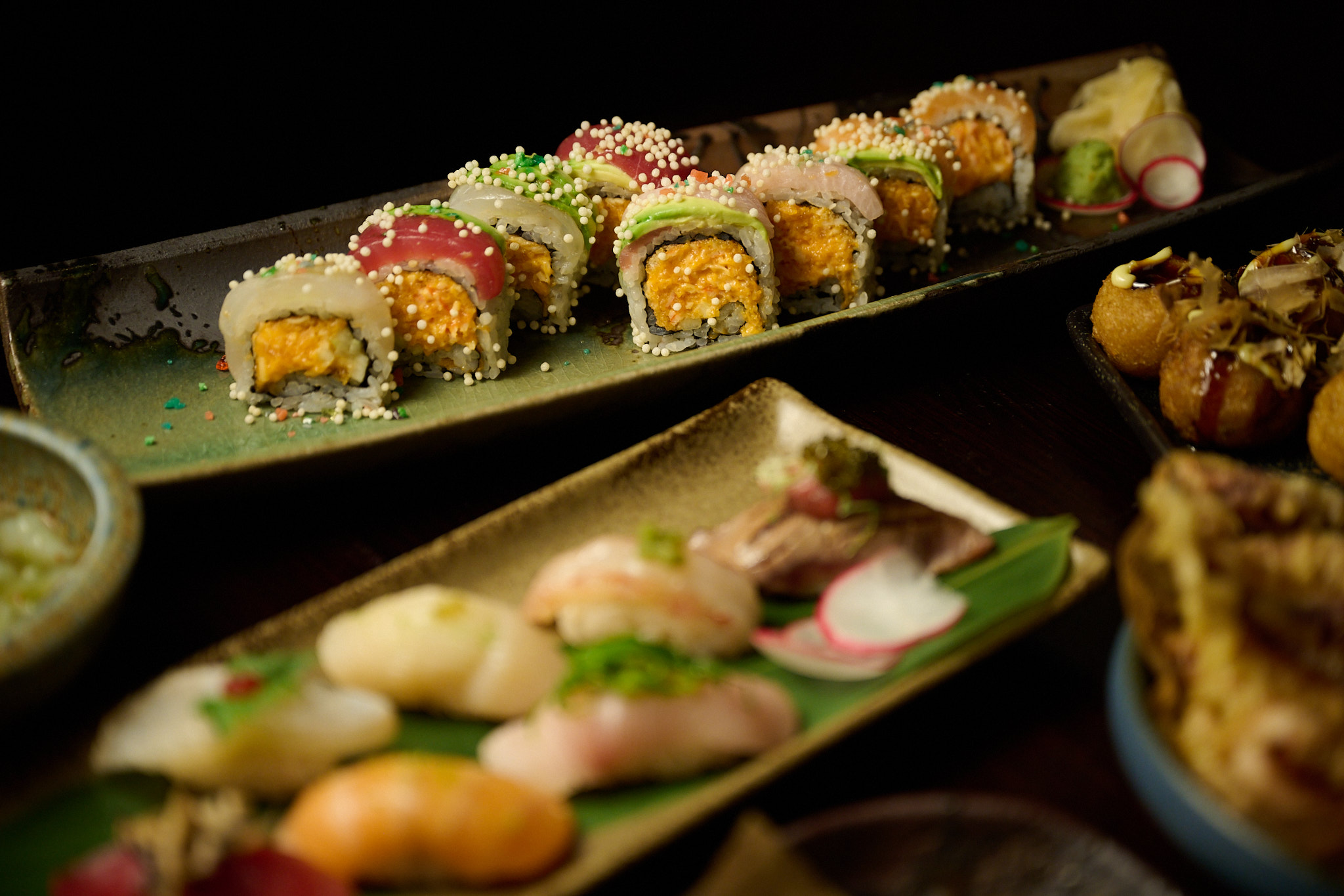 Feast spread featuring signature rolls, nigiri and takoyaki at Showa Era Izakaya NYC